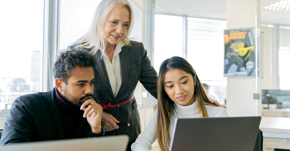 A mentor helping colleagues review their work